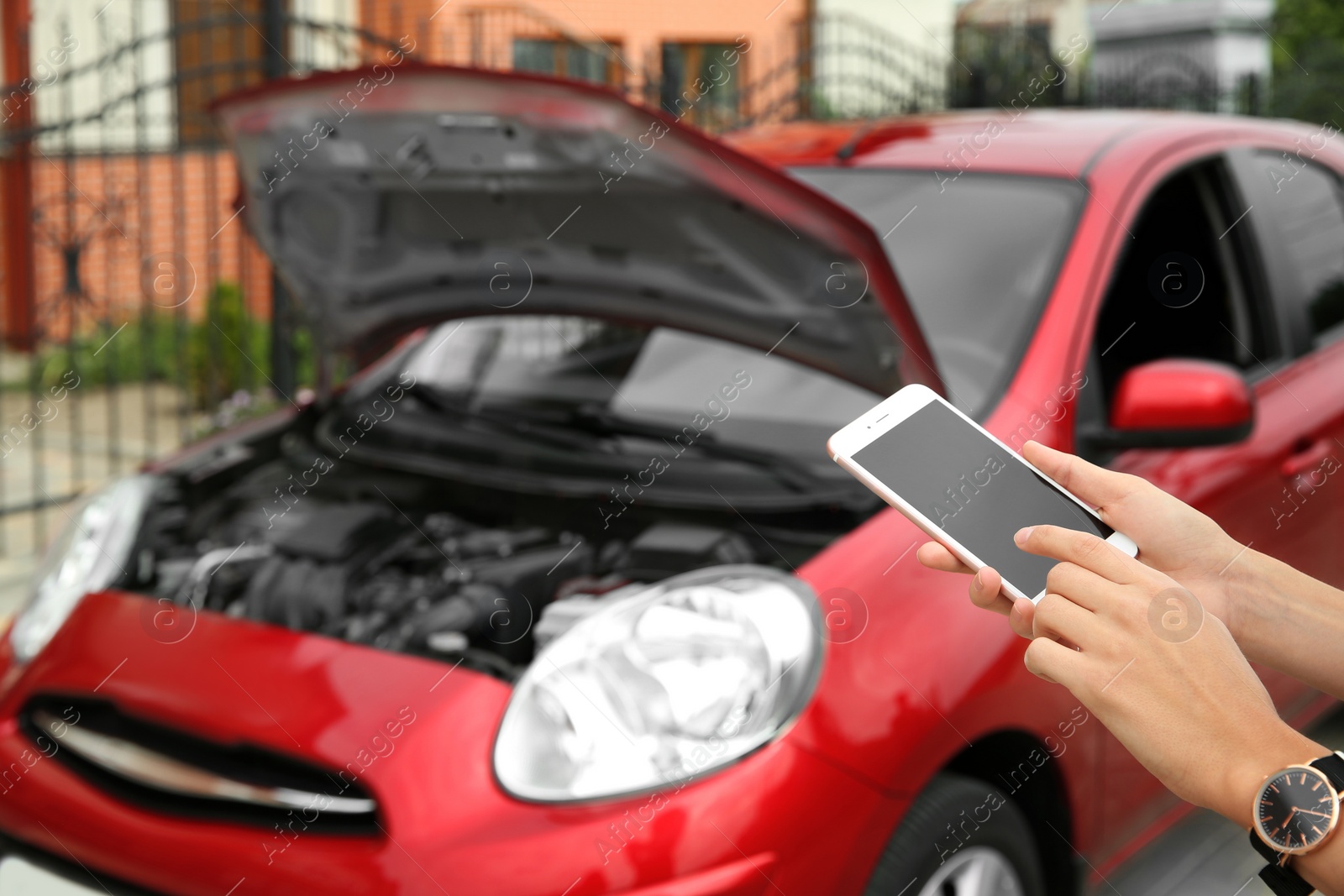 Photo of Woman with smartphone near broken car, closeup