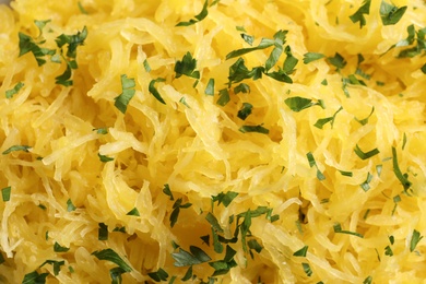 Cooked spaghetti squash with parsley as background, top view
