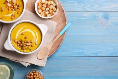 Delicious cream soup with chickpeas on light blue wooden table, flat lay. Space for text