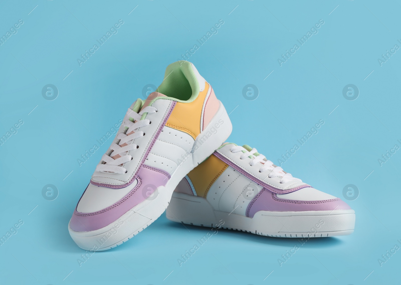 Photo of Pair of comfortable sports shoes on light blue background