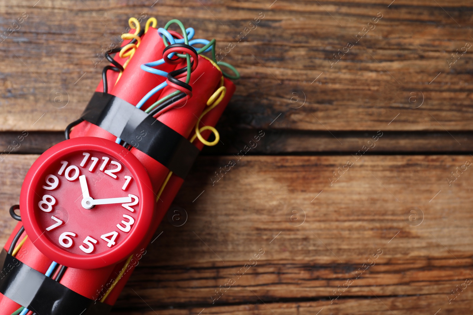 Photo of Dynamite time bomb on wooden table, top view. Space for text