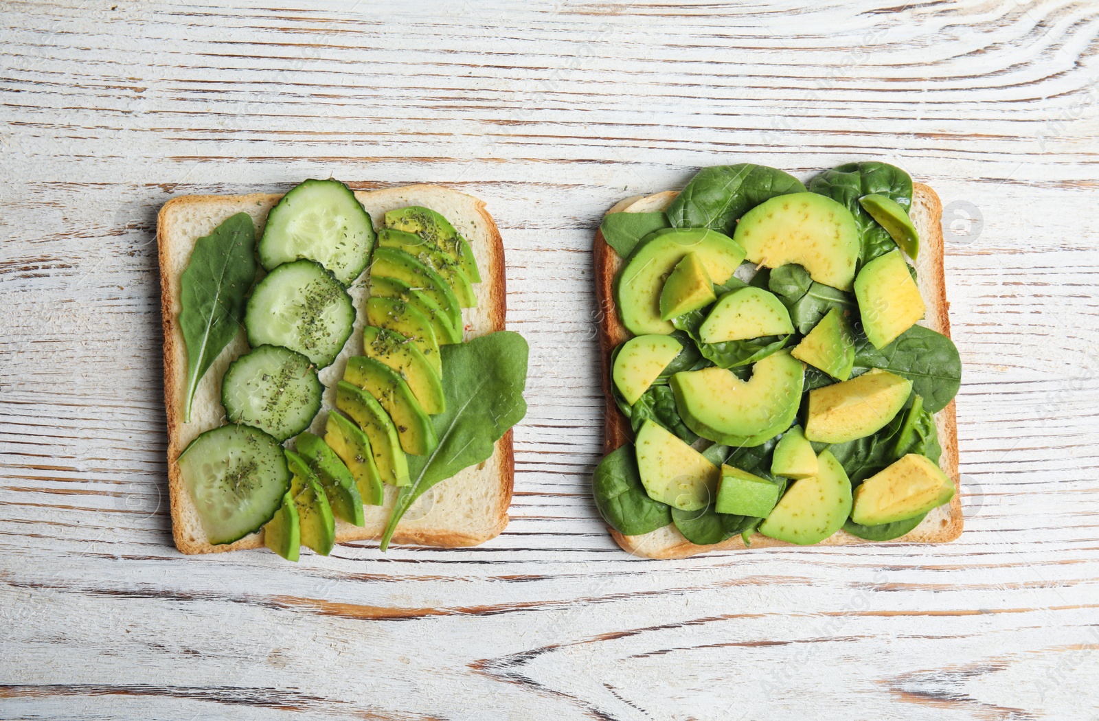 Photo of Tasty avocado toasts on white wooden table, flat lay