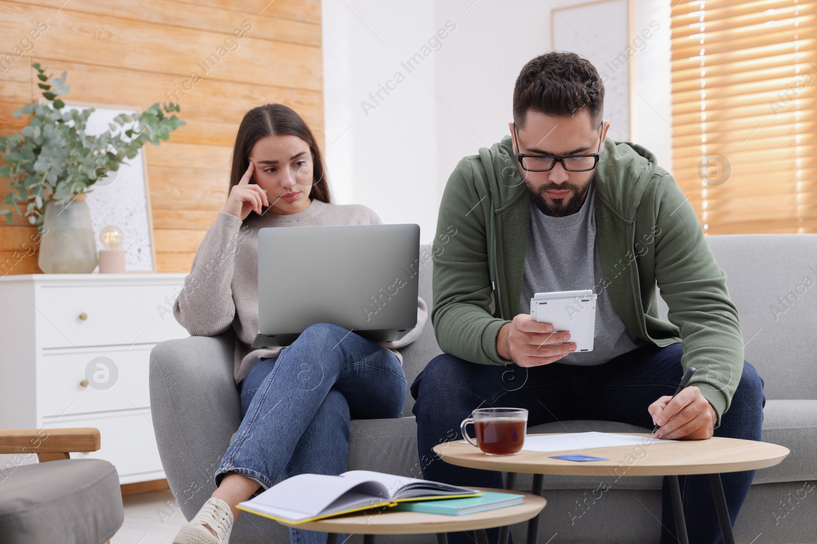 Photo of Young couple discussing family budget at home