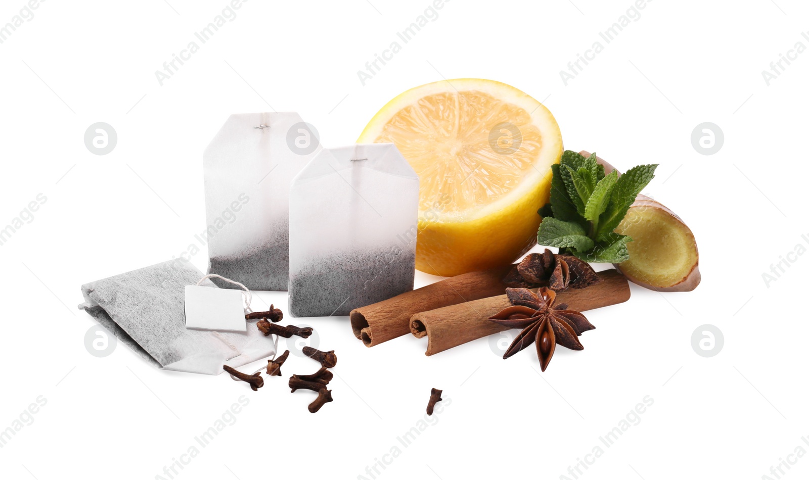 Photo of Tea bags, spices and half of lemon on white background