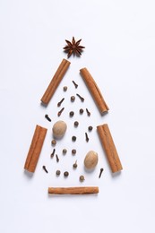 Photo of Christmas tree made of different spices on white table, flat lay