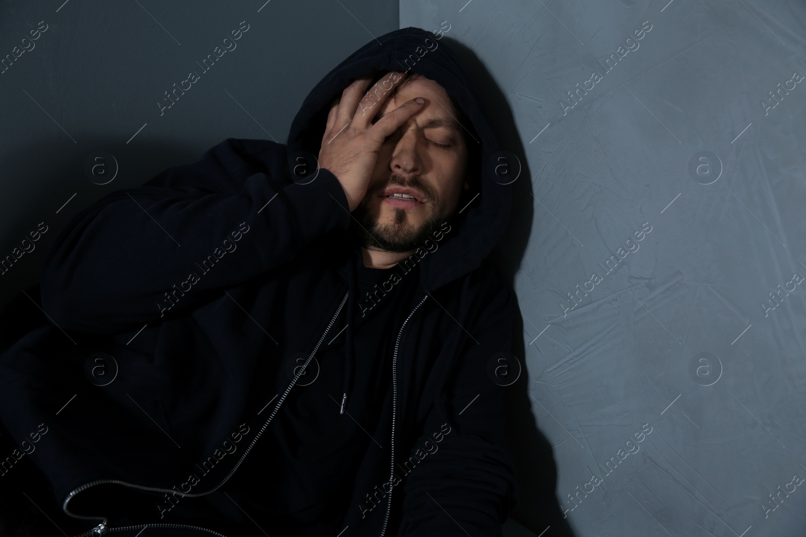 Photo of Passed out junkie after using drugs near grey wall