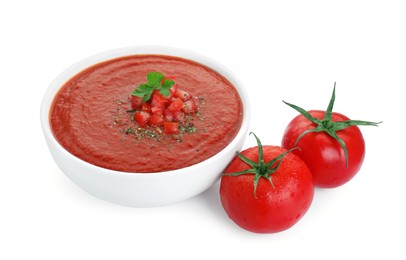 Photo of Delicious tomato cream soup in bowl and fresh tomatoes isolated on white