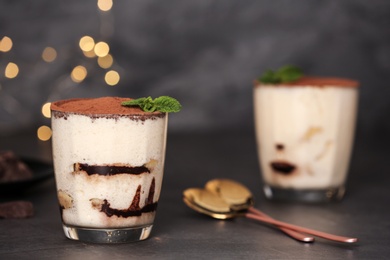 Photo of Tiramisu cake in glass on table, space for text