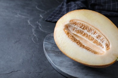Delicious honey melon on black table, closeup. Space for text