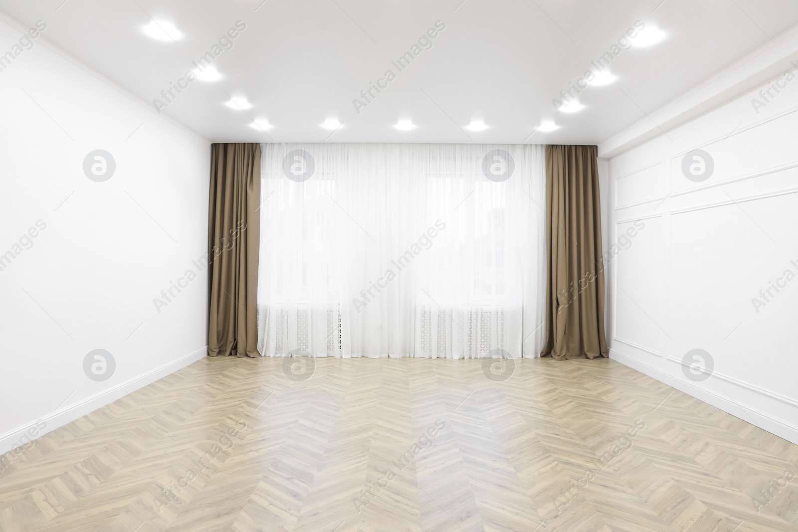 Photo of Empty room with white walls, large window and wooden floor