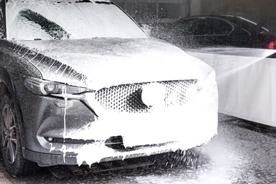 Photo of Cleaning automobile with high pressure water jet at car wash
