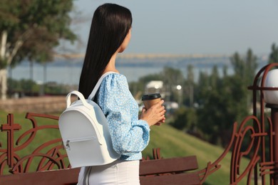 Young woman with stylish white backpack and coffee outdoors