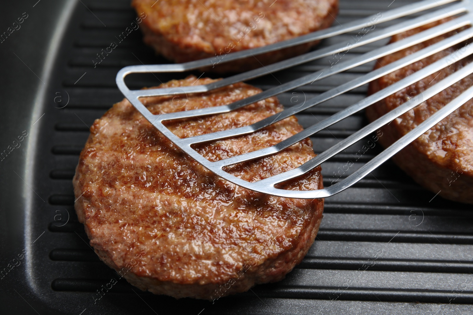 Photo of Tasty fried hamburger patties on grill pan, closeup