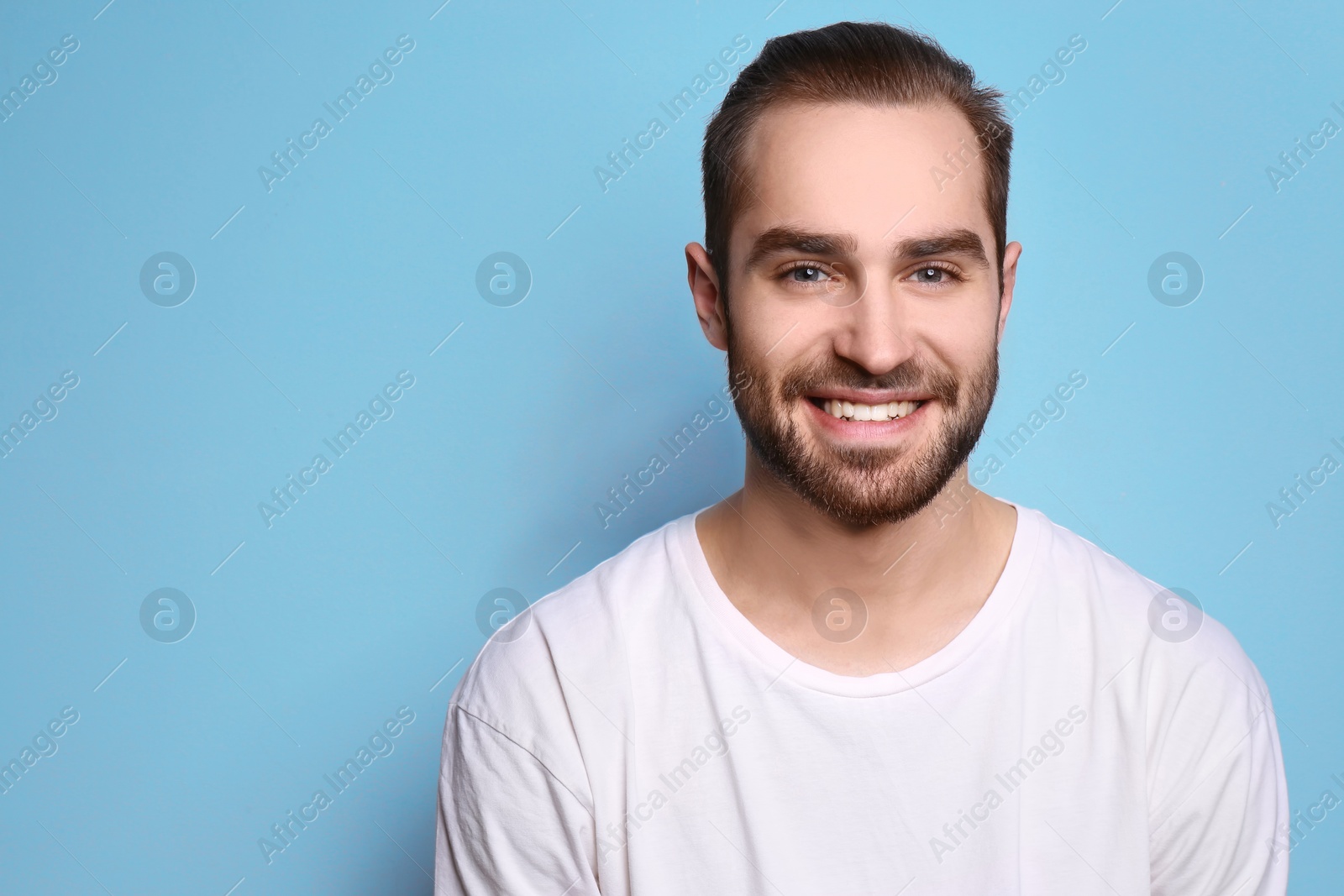 Photo of Young man with beautiful smile on grey background. Teeth whitening