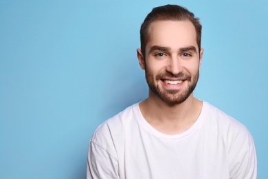 Photo of Young man with beautiful smile on grey background. Teeth whitening