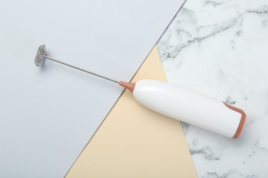 White milk frother wand on color background, top view