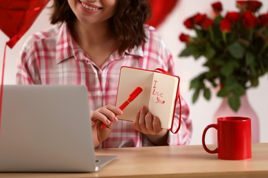 Photo of Valentine's day celebration in long distance relationship. Woman having video chat with her boyfriend via laptop indoors, closeup