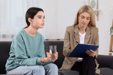 Photo of Psychologist working with teenage girl in office. Teenager problems