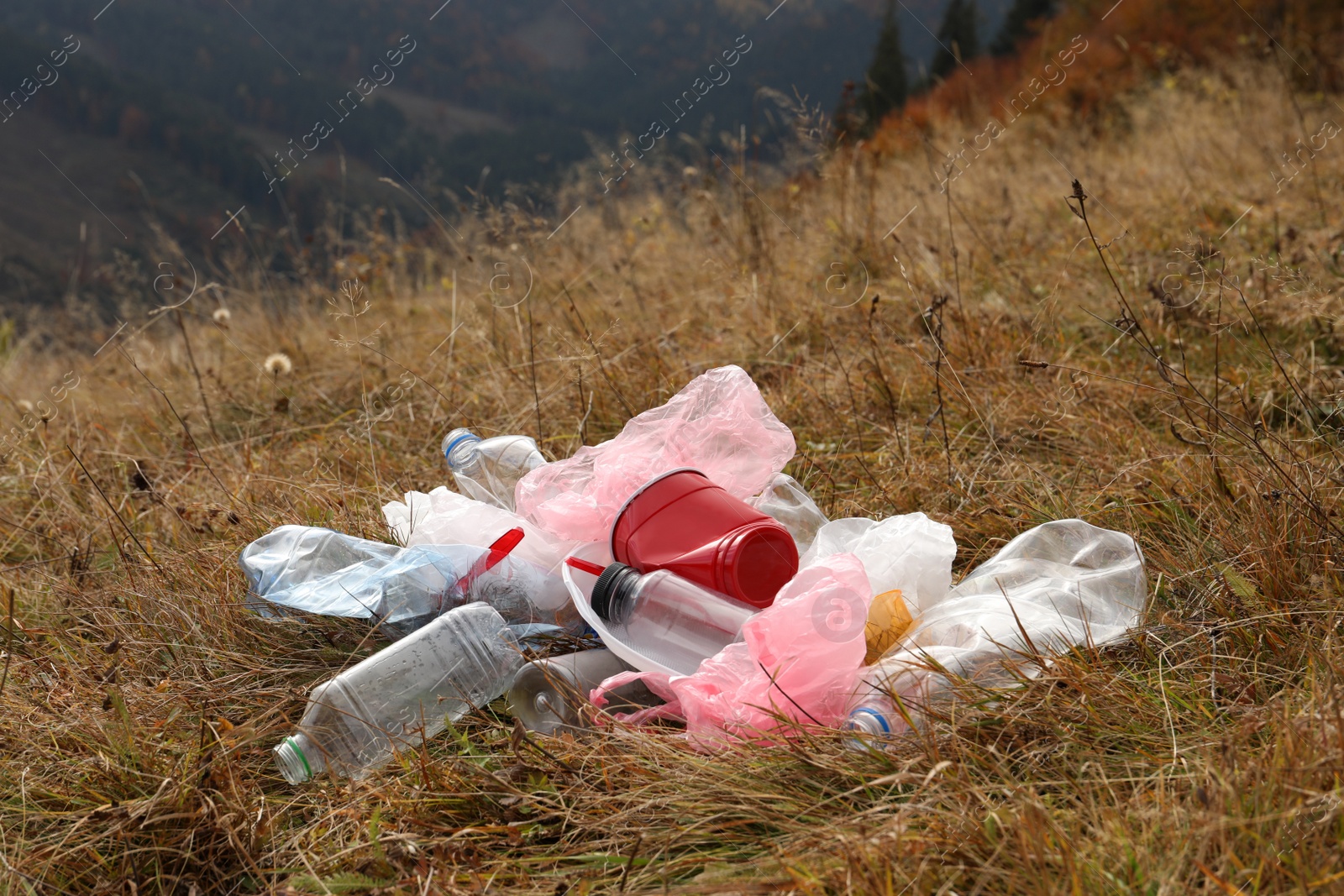 Photo of Pile of plastic garbage on grass in nature