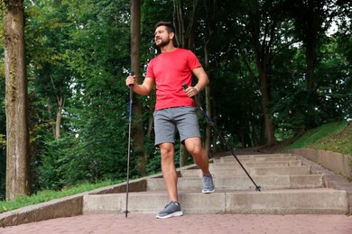 Man practicing Nordic walking with poles on steps outdoors, low angle view