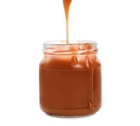 Tasty caramel sauce pouring into jar isolated on white