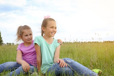 Photo of Cute happy girls on green grass in field. Space for text