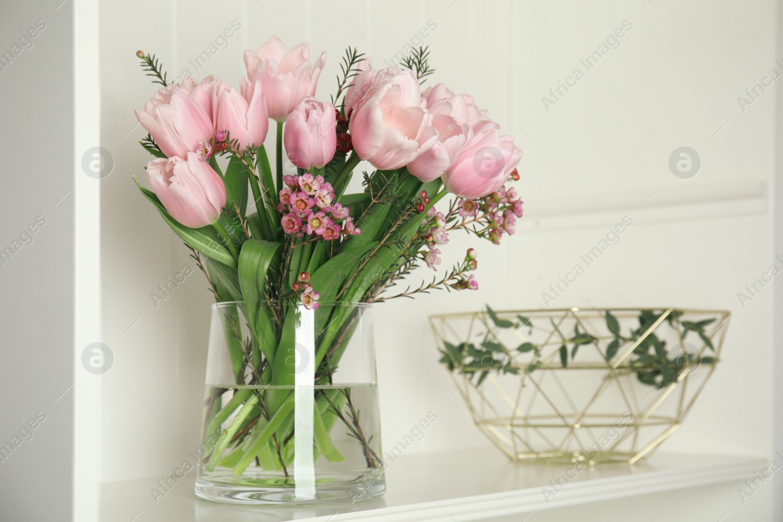 Photo of Beautiful bouquet with spring pink tulips on shelf