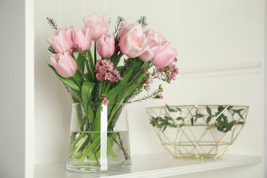 Beautiful bouquet with spring pink tulips on shelf