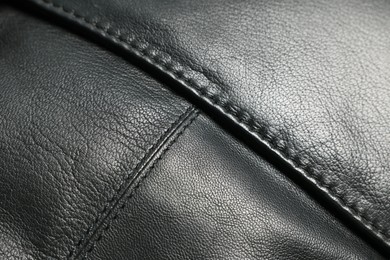 Photo of Black natural leather with seams as background, closeup view