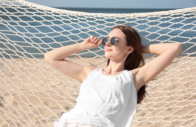 Photo of Young woman relaxing in hammock on beach