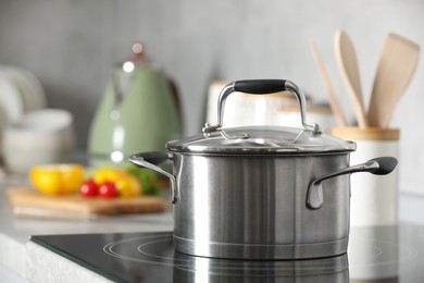 Photo of New shiny pot with glass lid in kitchen