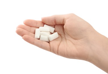 Photo of Woman holding pile of chewing gum pieces on white background, closeup