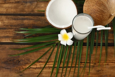 Photo of Composition with glass of coconut water on wooden background, top view