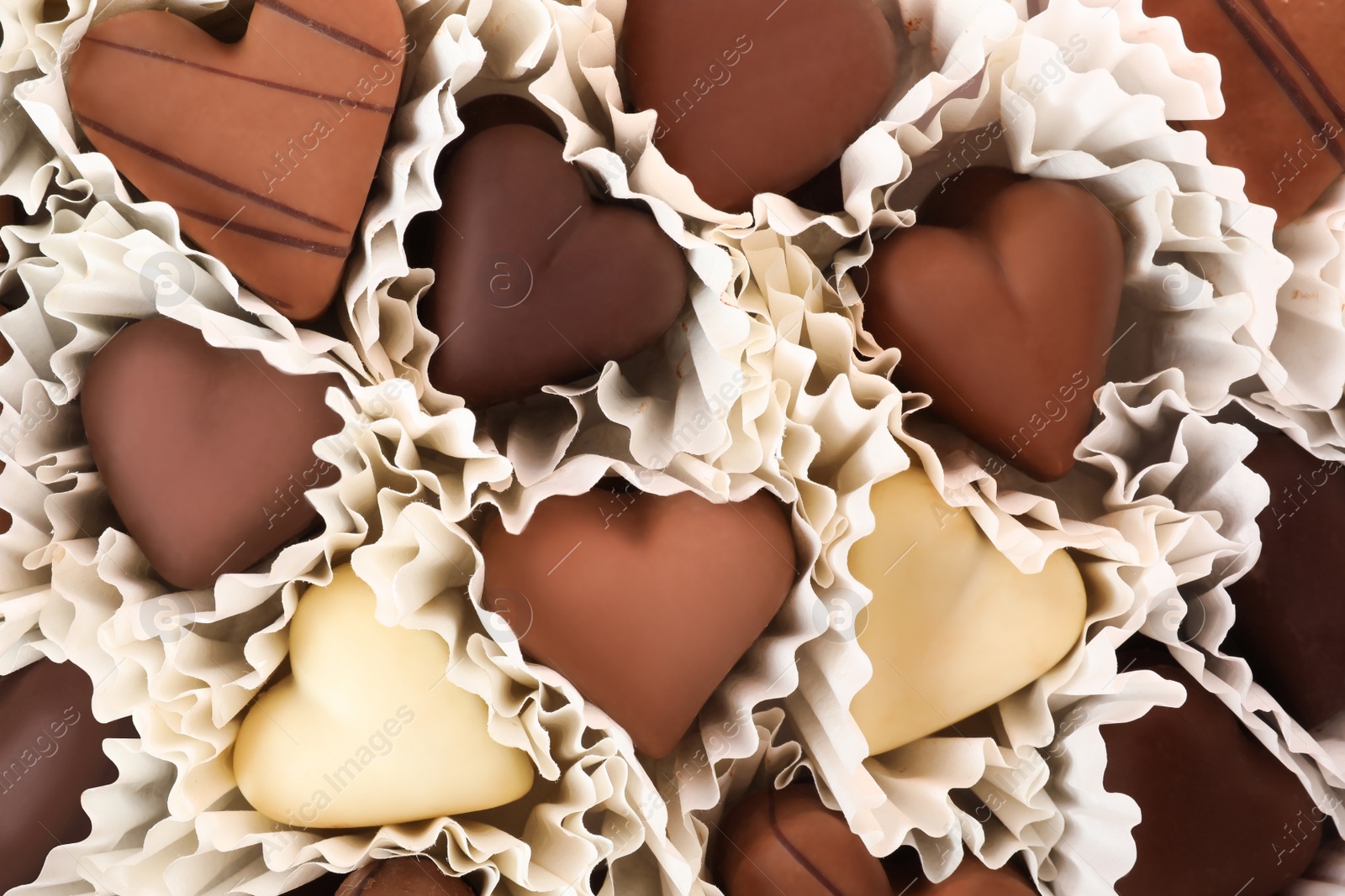 Photo of Delicious heart shaped chocolate candies as background, closeup