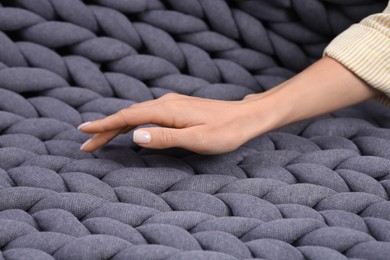 Photo of Woman touching grey chunky knit plaid, closeup