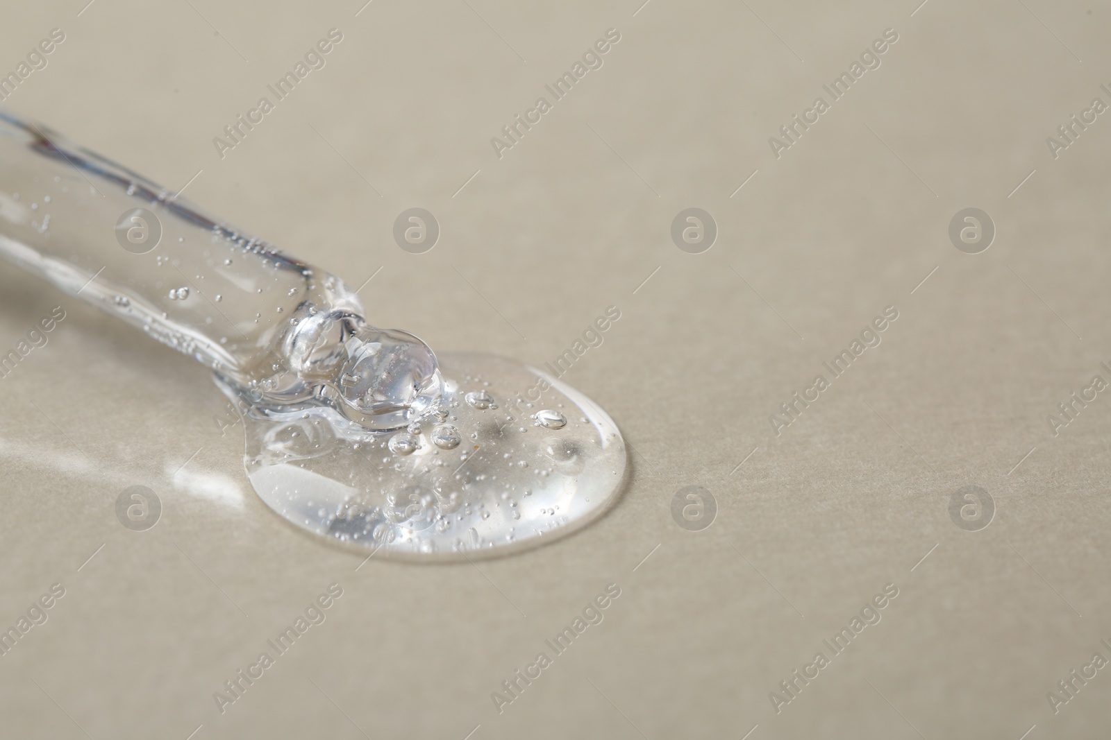 Photo of Pipette with cosmetic serum on beige background, macro view. Space for text