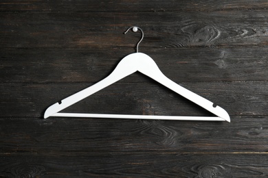 Photo of Empty clothes hanger on wooden wall. Wardrobe accessory