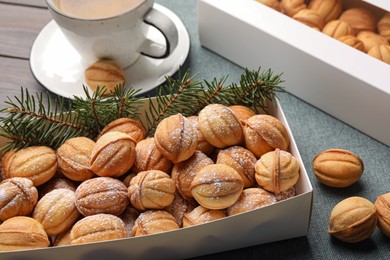 Box with delicious nut shaped cookies on wooden table