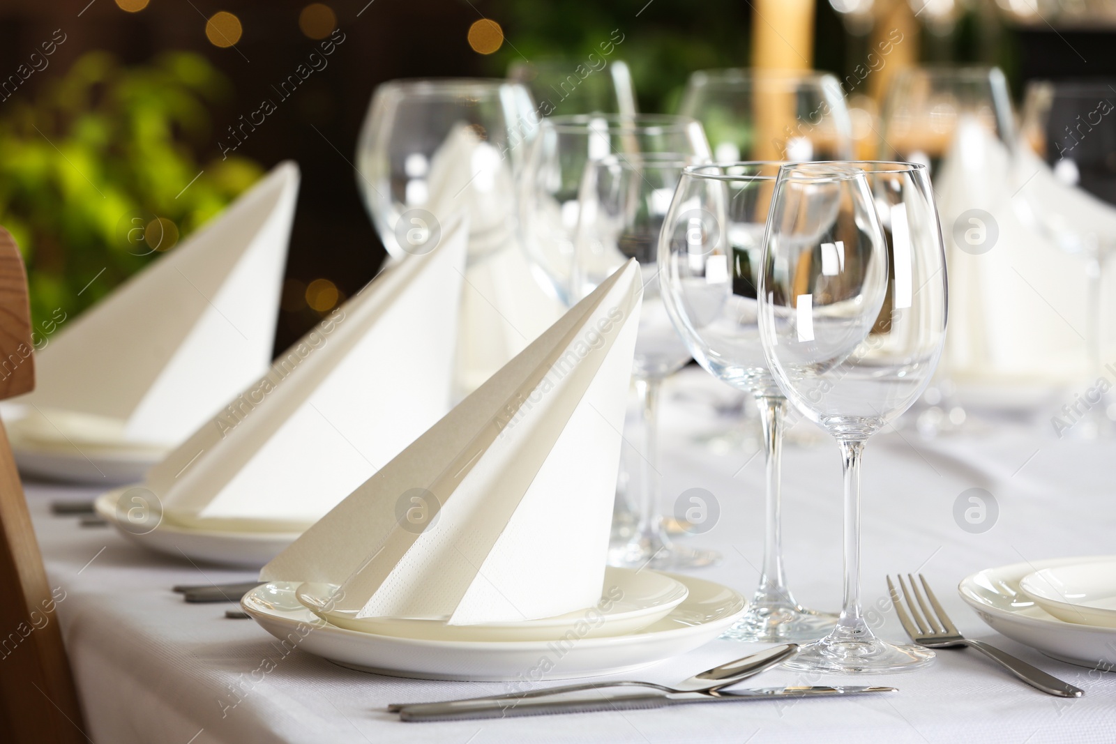 Photo of Table setting with empty glasses, plates and cutlery indoors