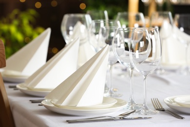 Table setting with empty glasses, plates and cutlery indoors