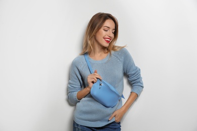 Photo of Beautiful young woman in warm sweater with bag on white background