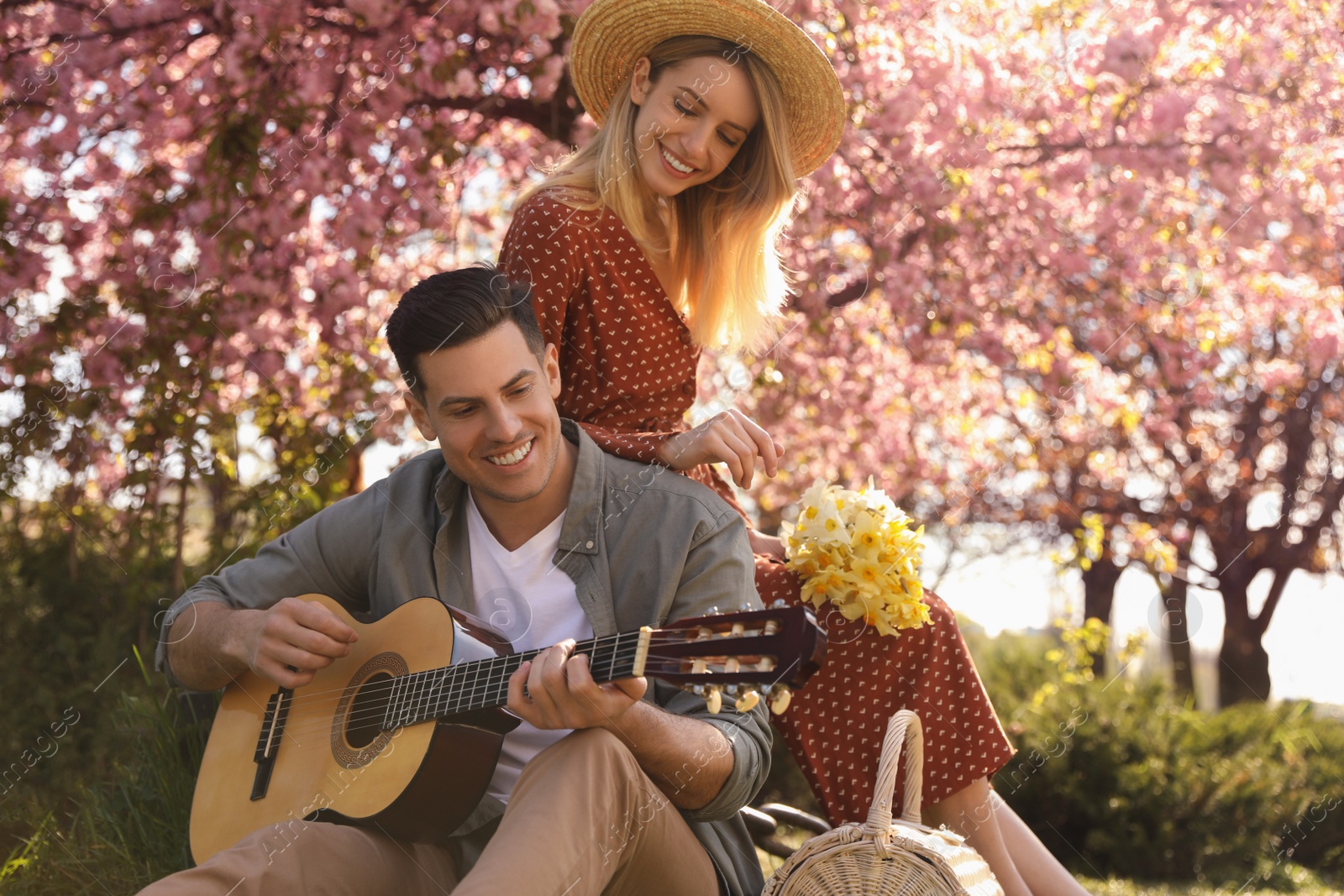 Photo of Lovely couple having picnic in park on sunny spring day