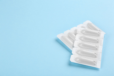 Photo of Suppositories on light blue background. Hemorrhoid treatment