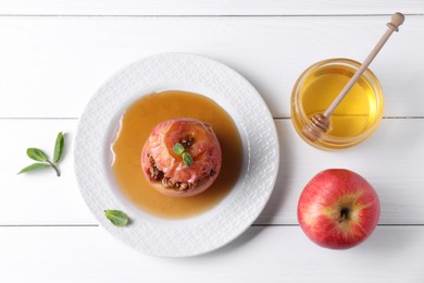 Photo of Tasty baked apple with nuts, honey and mint on white wooden table, flat lay