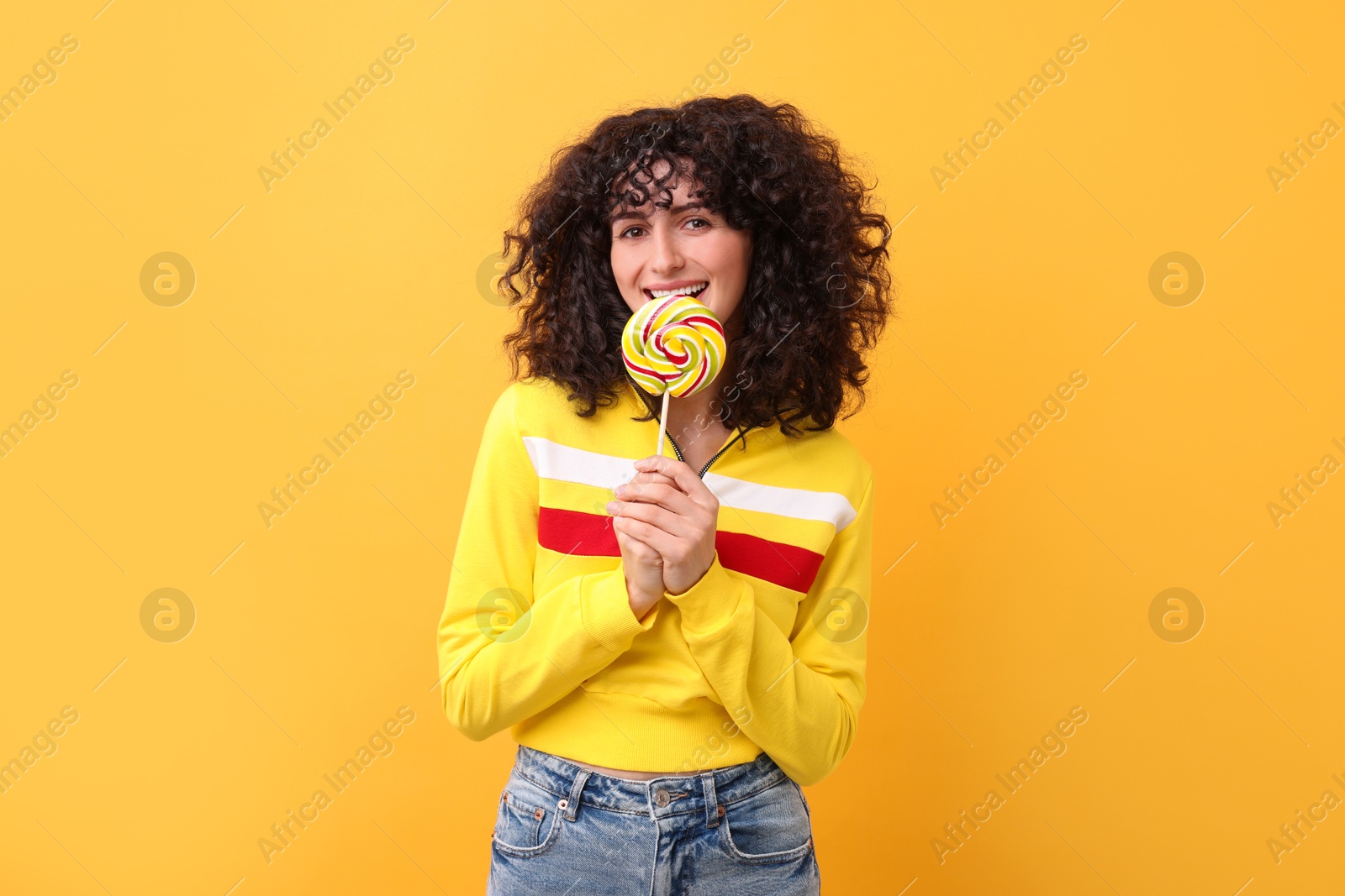 Photo of Beautiful woman with lollipop on yellow background