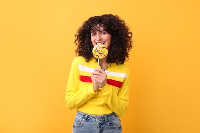 Photo of Beautiful woman with lollipop on yellow background