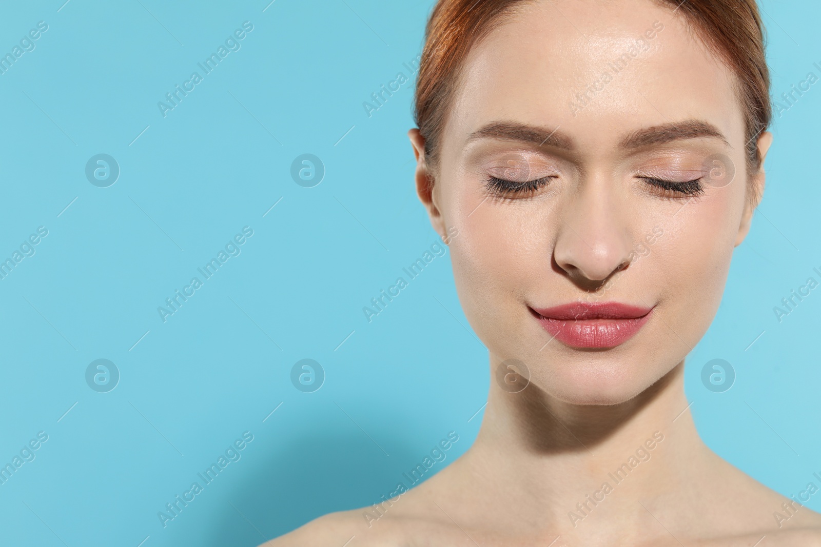 Photo of Beautiful young woman on light blue background. Space for text