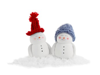 Cute decorative snowmen and artificial snow isolated on white