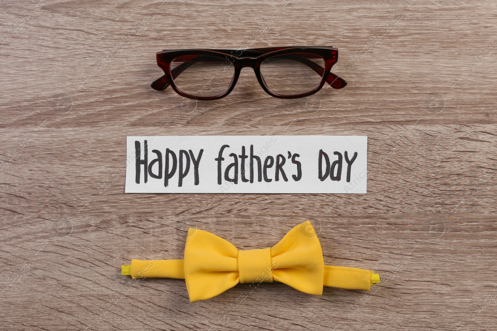 Photo of Bow tie and glasses on wooden background. Father's day celebration