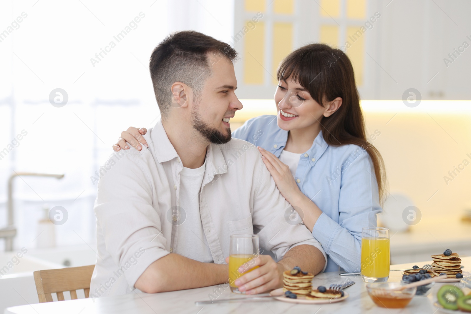 Photo of Happy couple spending time together during breakfast at home